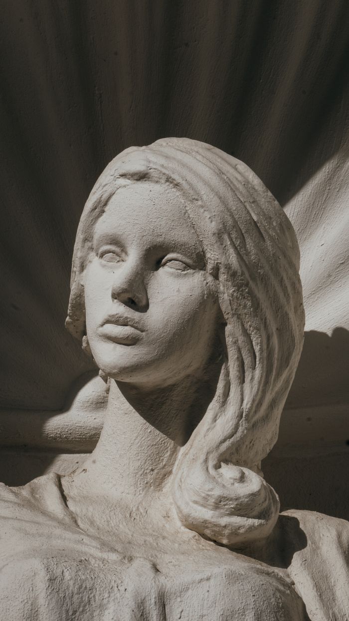 my-path Elegant stone sculpture of a young woman's face in soft light, showcasing artistic detail.