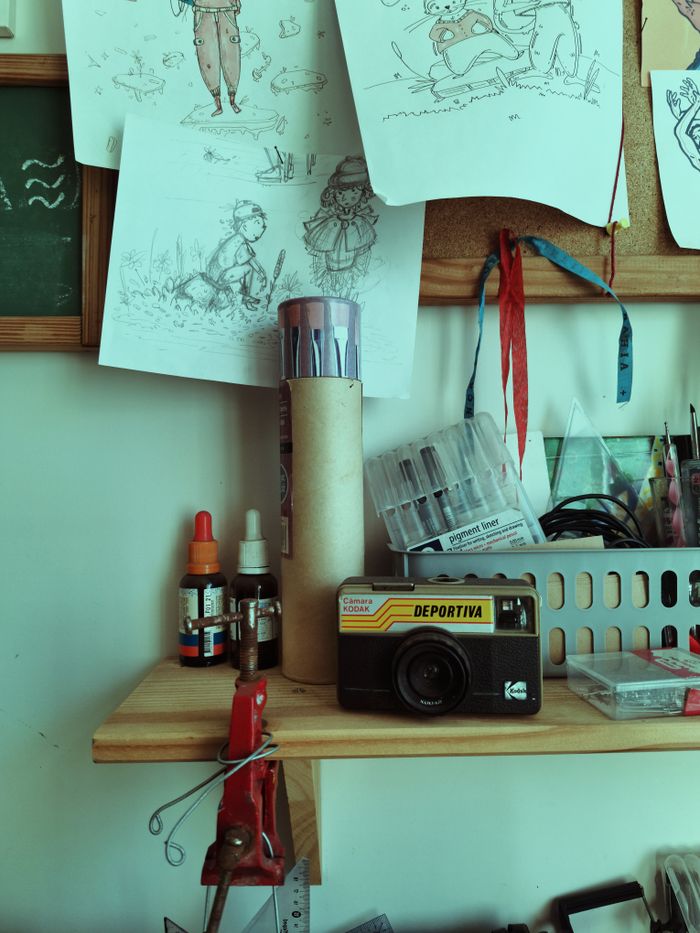 services-01 A creative workshop featuring a vintage camera and art supplies on a wooden shelf.