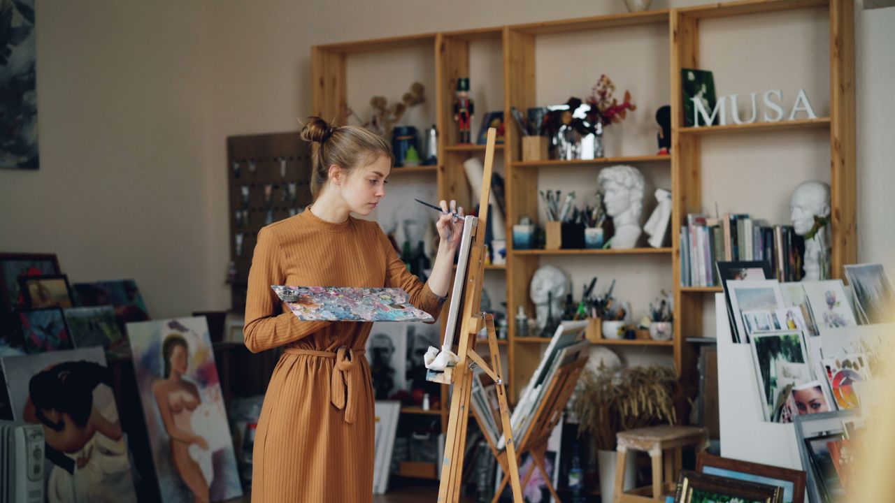 client-stories-img Female artist working on canvas in her art studio.