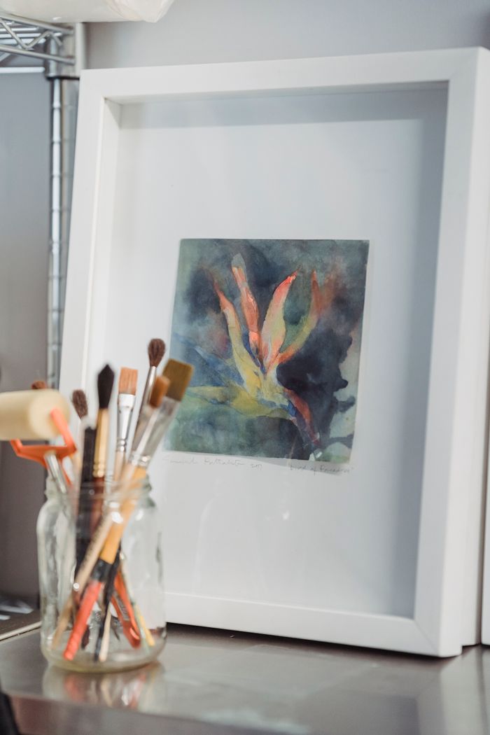 services-03 Framed abstract watercolor painting with paintbrushes in a clear jar.